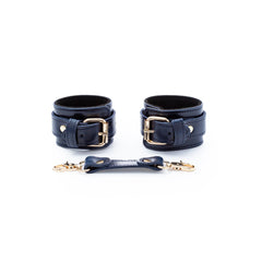 Two dark blue leather cuffs with gold buckles on a white background.