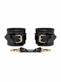 patent Black leather cuffs with gold buckles on a white background